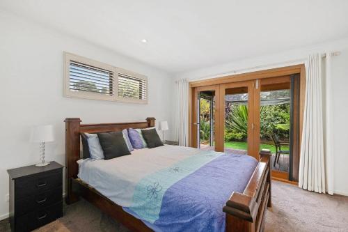 a bedroom with a bed and a window at Andrea and Nigel's Beach House in Cape Woolamai