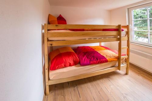 a bunk bed with colorful pillows on the bottom bunk at Campingplatz am Hünstein in Nohra