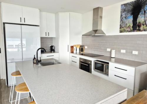 a white kitchen with a sink and a counter at The Nebraska Retreat in Dennes Point