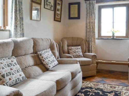 a living room with a couch and a chair at Titchbourne Cottage in Clee Saint Margaret