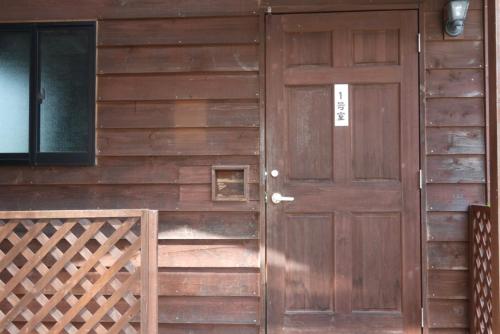 a wooden door on the side of a building at コテージZen in Kyotango