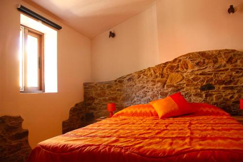 ein Schlafzimmer mit einem Bett mit einem roten Kissen in der Unterkunft Casas dos Carregais in Carregais