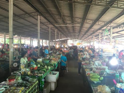 a market with a lot of people in a room with fruits and vegetables at AG Property in Mae Pim