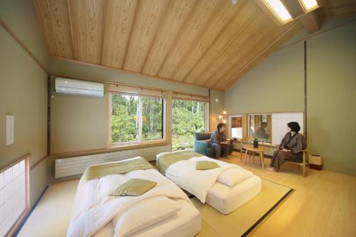 a living room with two people sitting in a room at Morinoryotei Biei in Biei