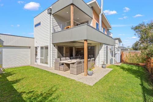 a house with a balcony with a table and chairs at Stylish Townhouse Opposite Golfcourse in Cowes