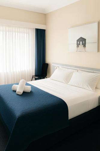 a bedroom with a bed with two towels on it at Banksia Motel Bass Hill in Bass Hill