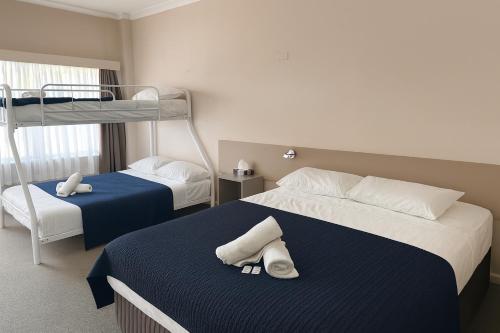 a bedroom with two beds and a bunk bed at Banksia Motel Bass Hill in Bass Hill