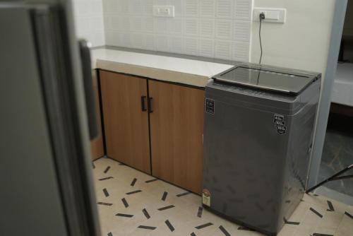 a kitchen with a counter and a trash can at Jo Homes Apartments in Alwaye
