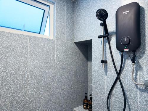 a shower with a blow dryer in a bathroom at Stallionz Ipoh by ANGO in Ipoh