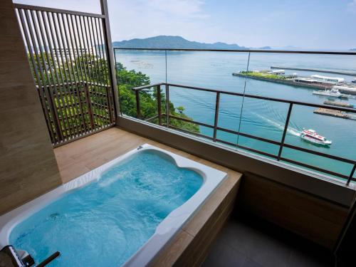 a bath tub on a balcony with a view of the water at Todaya in Toba