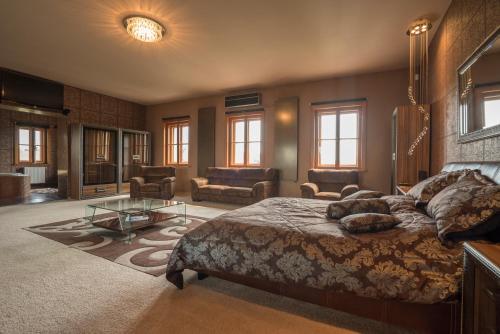 a bedroom with a large bed and a living room at Villa Malom Luxury Resort in Pusztazámor