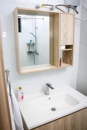 ein Badezimmer mit Waschbecken und Spiegel in der Unterkunft Sunset Stays near UN, Two Rivers & Village Market with Gym & Pool in Ruaka