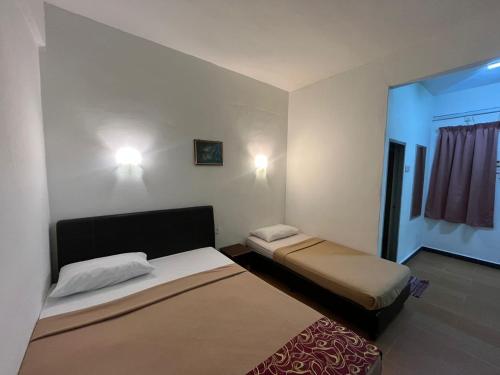 a small room with two beds in a room at Collection O Analisa Beach Resort in Pangkor