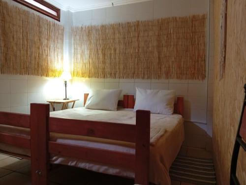 a small bedroom with a bed and a lamp at 566 Hostel in La Serena