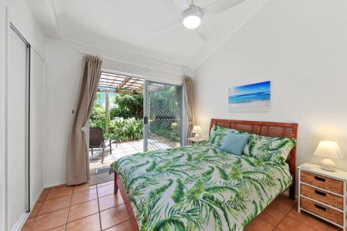 a bedroom with a bed and a sliding glass door at Mudjimba Esp Villa-Beachfront-Pet friendly in Mudjimba