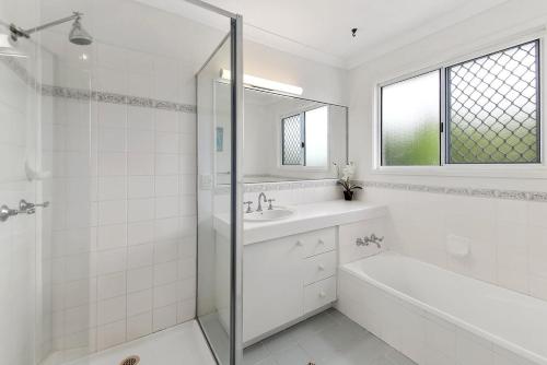 a white bathroom with a sink and a shower at Mudjimba Esp Villa-Beachfront-Pet friendly in Mudjimba