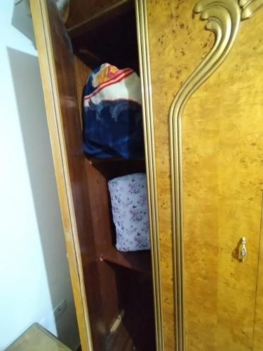 a wooden cabinet with a blue bag in it at Pink Horizon Homestay - for Men ONLY in Dumyāţ al Jadīdah