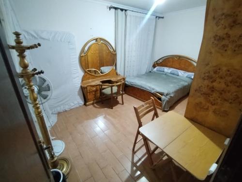 a bedroom with a bed and a table and chairs at Pink Horizon Homestay - for Men ONLY in Dumyāţ al Jadīdah
