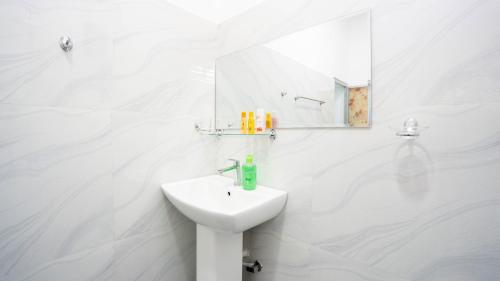 a white bathroom with a sink and a mirror at Dambulla Village Hotel in Dambulla