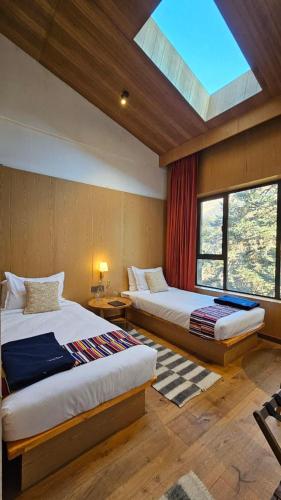a bedroom with two beds and a skylight at The Himalayan Tyangboche in Thyāngboche