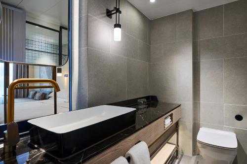 a bathroom with a tub and a toilet and a sink at Sheraton Hong Kong Hotel & Towers in Hong Kong