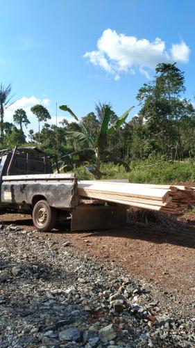 a truck with a pile of wood on the back at Kotabaru in Gununganjar