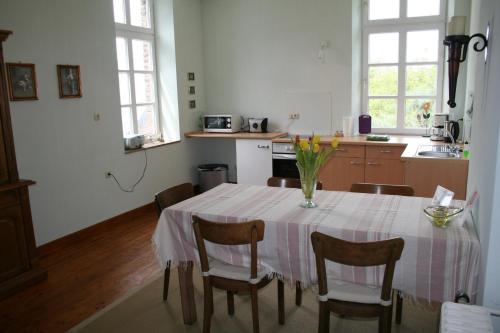 eine Küche mit einem Tisch und einer Blumenvase darauf in der Unterkunft Timmermannshof in Xanten