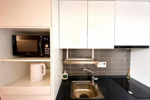a kitchen with a sink and a microwave at 더 디셈버스테이 인 한라 in Taeam