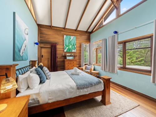a bedroom with a large bed and windows at Kookaburra Retreat - Dog Friendly - Forest View in Gnarabup
