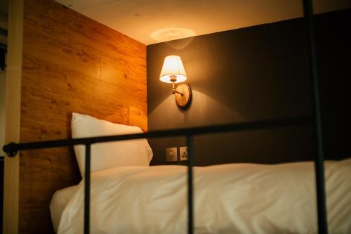 a bedroom with a bed with a lamp on the wall at NK Hostel in Taipei