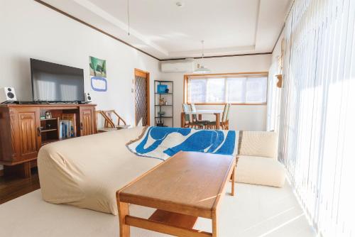 a bedroom with a bed and a couch and a table at 諏訪絶景ハウス - Suwa Panorama House in Suwa