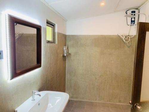 a bathroom with a sink and a shower at Elephant Trail Homestay in Habarana