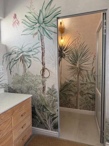 a bathroom with a palm tree mural on the wall at McGregor Hideaways in McGregor