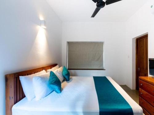 a bedroom with a large white bed with blue pillows at Serendipity in Colombo