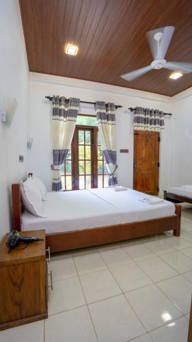 a bedroom with a large bed with a ceiling at Dambulla Village Hotel in Dambulla