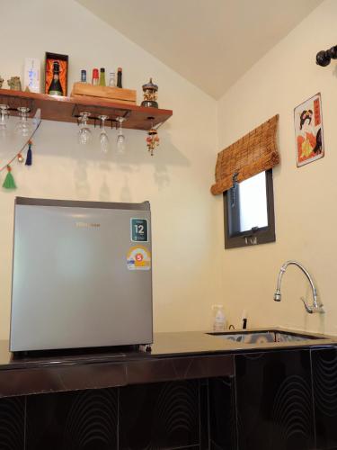 a kitchen with a sink and a laptop on a counter at chananthida suyarach in Ban Mai Na Hi