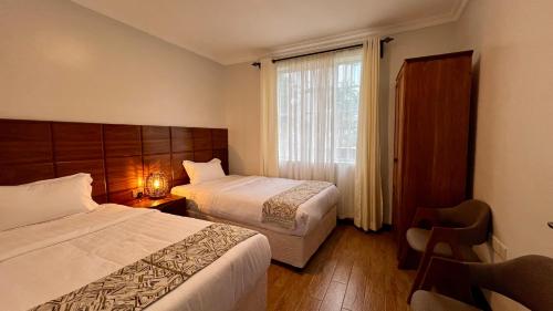 a hotel room with two beds and a window at Iwandaa Apartments in Nkoanrua