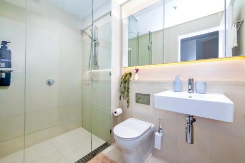 a bathroom with a toilet and a sink and a shower at The Quarter Elite 1BR Resort-Style Amenities in Melbourne