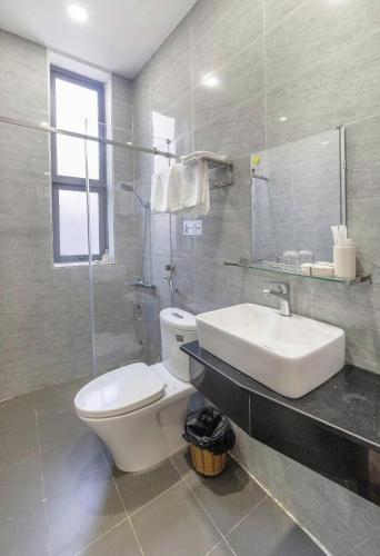 a bathroom with a white toilet and a sink at Hamilton Villa Da Lat - Pine Tree n Valley View in Khu Chi Lăng