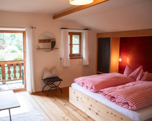a bedroom with two beds and a balcony at Fannys in Weißach