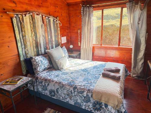 a bedroom with a bed in a wooden cabin at Serendipity Guest Farm Byrne in Byrne