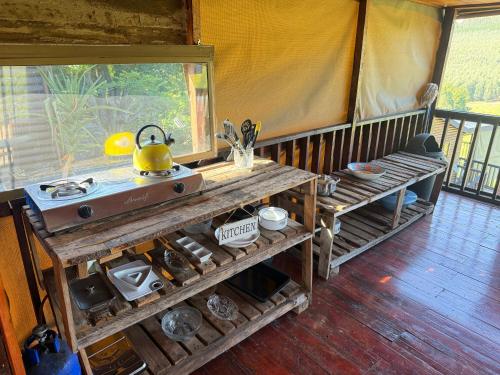 a kitchen in a tent with a tea kettle on it at Serendipity Guest Farm Byrne in Byrne