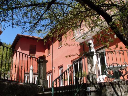 a pink house with a fence in front of it at Hotel Roma in Scanno