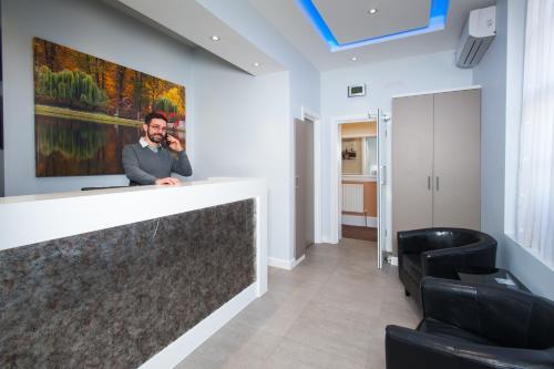 a man talking on a cell phone in a lobby at Dover Hotel - B&B in London