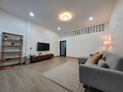 a living room with a couch and a flat screen tv at Ama'home in Hat Yai