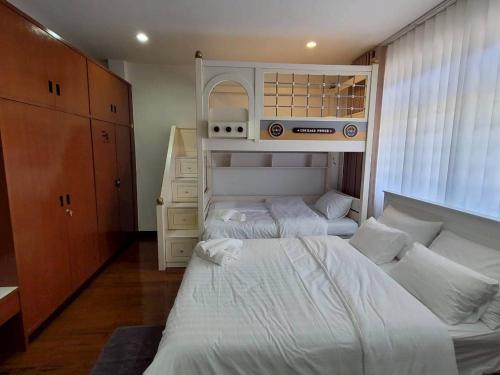 a bedroom with two beds and a dresser at Ama'home in Hat Yai
