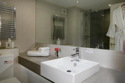 y baño con lavabo blanco y espejo. en Best Western Gables Hotel en Falfield