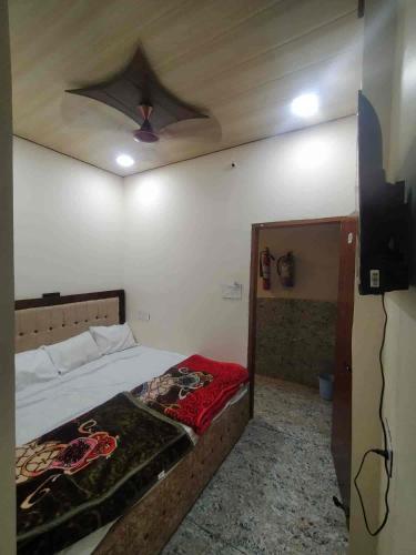 a bedroom with a bed with a ceiling fan at GeetKamal Palace Ayodhya Dham in Ayodhya