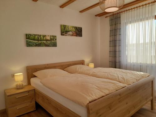 a bed in a bedroom with a window and two lamps at Gasthof Siebenstern in Röslau