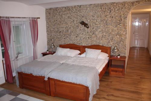 セゲドにあるBelváros Anna-kuti Apartmanのベッドルーム1室(木製ベッド1台、ナイトスタンド2台付)